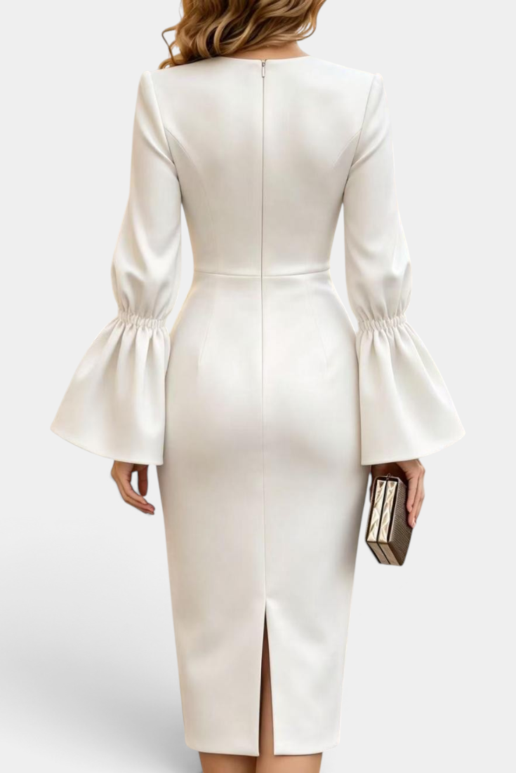 Back view of Mahaute Demelza white midi sheath dress with flared sleeves and back slit on a model holding a clutch.