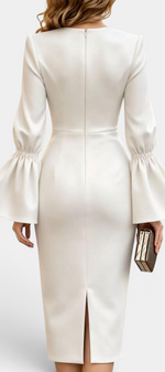 Back view of Mahaute Demelza white midi sheath dress with flared sleeves and back slit on a model holding a clutch.