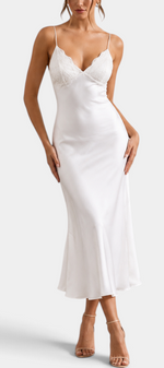 Mahaute white satin maxi dress with spaghetti straps and delicate lace V-neckline on a model