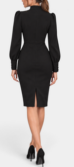 Back view of Mahaute Yordanka black midi dress with puff sleeves, buttoned cuffs, and a back slit on a model