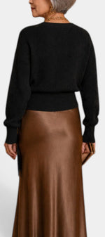 Mahaute Zia black ribbed knit sweater with long sleeves worn with a brown satin midi skirt, back view