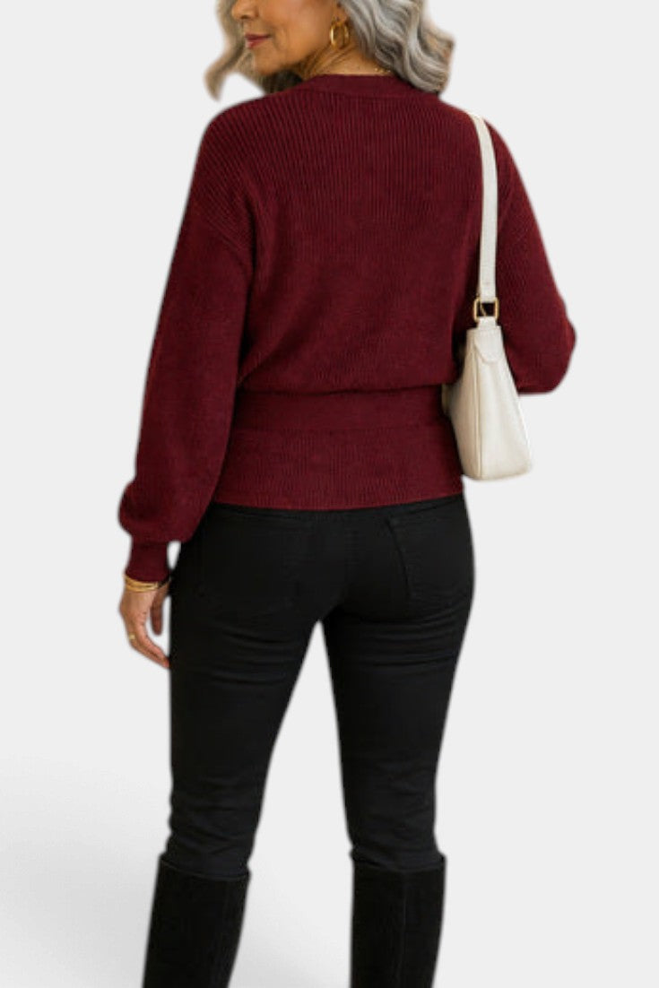 Back view of a woman wearing a Mahaute burgundy ribbed knit wrap sweater with long sleeves and a tied waist.