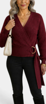 Mahaute Zia burgundy wrap sweater with V-neck, tie waist, and voluminous sleeves worn by a woman with gold jewelry.
