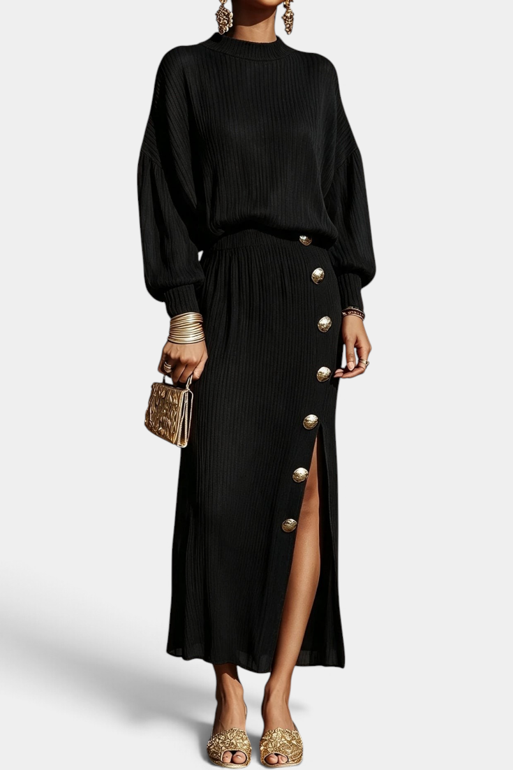 Mahaute Zornitsa black pleated two-piece set featuring a fluid blouse and a long skirt with gold button side slit.