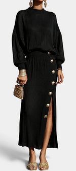 Mahaute Zornitsa black pleated two-piece set featuring a fluid blouse and a long skirt with gold button side slit.